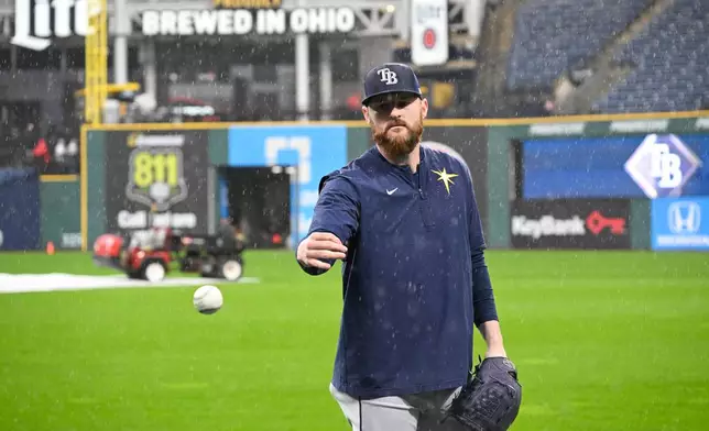 Tampa Bay Rays pitcher Bryan Baker warms up in the rain during batting practice before Game 4 of an American League Championship Series baseball game against the Cleveland Guardians in Cleveland, Friday, Oct. 16, 2026. (AP Photo/Phil Long)