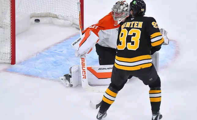 Philadelphia Flyers goaltender Dan Vladar (80) watches as the puck sails into the net, on a goal by Boston Bruins defenseman Mason Lohrei, as Bruins center Fraser Minten (93) looks on in the second period of an NHL hockey game Saturday, Oct. 10, 2026, in Boston. (AP Photo/Steven Senne)