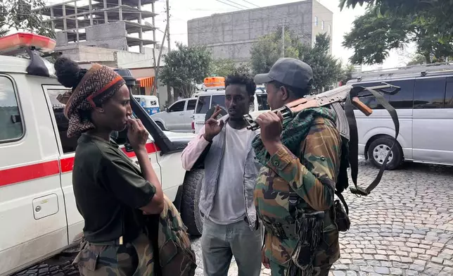 Tigray Peace Force fighters stand beside an ambulance after entering Mekelle, in Ethiopia’s Tigray region, Sunday, Oct. 4, 2026. (AP Photo/Filmon Equar Hailu)