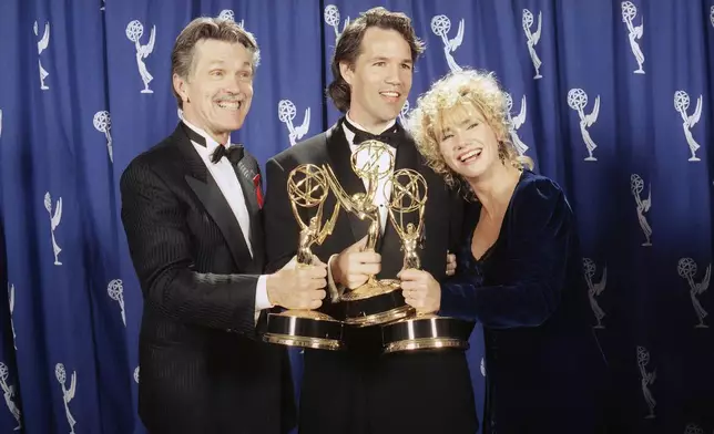 FILE - David E. Kelley, center, creator of "Picket Fences," poses with actors Tom Skerritt, left, and Kathy Baker after show won best drama series during the 45th annual Emmy Awards in Pasadena, Calif., on Sept. 19, 1993. (AP Photo/Douglas C. Pizac, File)