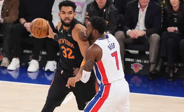 New York Knicks' Karl-Anthony Towns (32) protects the ball from Detroit Pistons' Paul Reed (7) during the first half of an NBA basketball game Tuesday, Oct. 27, 2026, in New York. (AP Photo/Frank Franklin II)