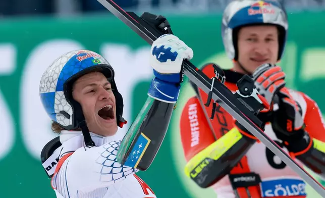 Brazil's Lucas Pinheiro Braathen celebrates winning an alpine ski, men's World Cup giant slalom as third-placed Switzerland's Marco Odermatt applauds in the background, in Soelden, Austria, Sunday, Oct. 25, 2026. (AP Photo/Alessandro Trovati)