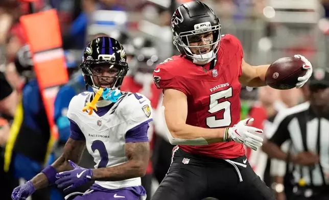 Atlanta Falcons wide receiver Drake London (5) catches a pass in front of Baltimore Ravens cornerback Nate Wiggins (2) during the first half of an NFL football game, Sunday, Oct. 11, 2026, in Atlanta. (AP Photo/Mike Stewart)