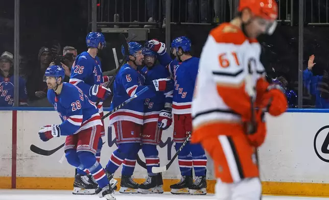 New York Rangers' Oliver Bjorkstrand (28) celebrates with teammates after scoring a goal as Anaheim Ducks' Cutter Gauthier (61) skates away during the second period of an NHL hockey game Monday, Oct. 19, 2026, in New York. (AP Photo/Frank Franklin II)