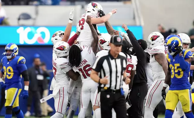 Arizona Cardinals kicker Chad Ryland, top, is congratulated by teammates after kicking the game winning field goal against the Los Angeles Rams during the second half of an NFL football game in Inglewood, Calif., Sunday, Oct. 18, 2026. (AP Photo/Gregory Bull)