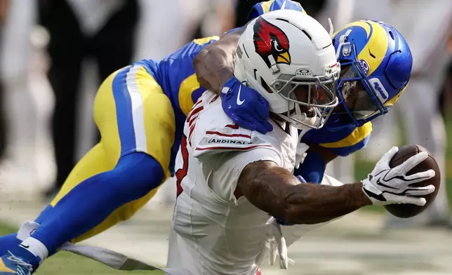 Arizona Cardinals wide receiver Kendrick Bourne, bottom, reaches forward with the ball while tackled by Los Angeles Rams cornerback Josh Wallace during the second half of an NFL football game in Inglewood, Calif., Sunday, Oct. 18, 2026. (AP Photo/Caroline Brehman)