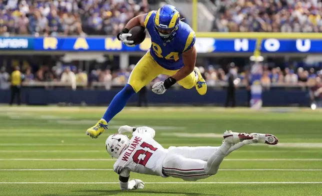 Los Angeles Rams tight end Colby Parkinson (84) jumps over Arizona Cardinals cornerback Garrett Williams during the first half of an NFL football game in Inglewood, Calif., Sunday, Oct. 18, 2026. (AP Photo/Gregory Bull)