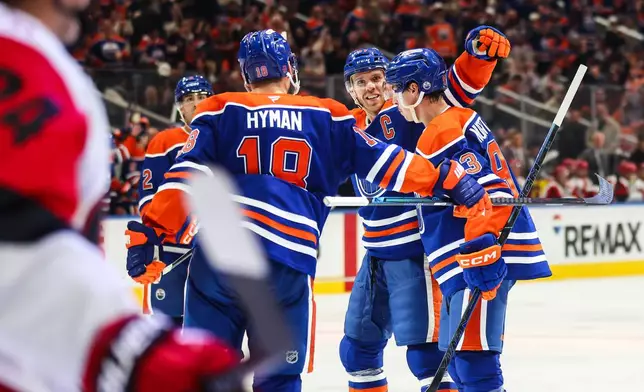 Edmonton Oilers' Zach Hyman (18), Connor McDavid (97) and Ryan Nugent-Hopkins, right, celebrate after Nugent-Hopkins' goal against the Carolina Hurricanes during the second period of an NHL hockey game in Edmonton, Alberta, Thursday, Oct. 22, 2026. (Codie McLachlan/The Canadian Press via AP)