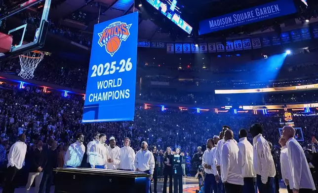 New York Knicks players look on as the 2025-26 World Champions banner is raised before an NBA basketball game between the Knicks and the Philadelphia 76ers Tuesday, Oct. 20, 2026, in New York. (AP Photo/Frank Franklin II)