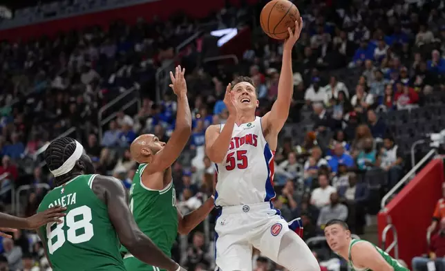 Detroit Pistons forward Duncan Robinson (55) shoots on Boston Celtics guard Derrick White (9) in the second half of an NBA basketball game in Detroit, Tuesday, Oct. 20, 2026. (AP Photo/Paul Sancya)