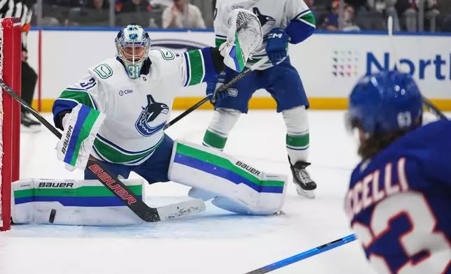 Vancouver Canucks goaltender Leevi Meriläinen (31) stops a shot by New York Islanders' Matias MacCelli (63) during the second period of an NHL hockey game Tuesday, Oct. 13, 2026, in Elmont, N.Y. (AP Photo/Frank Franklin II)