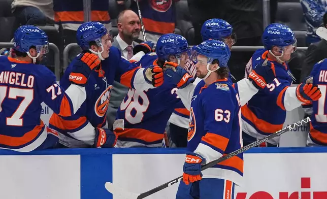 New York Islanders' Matias MacCelli (63) celebrates with teammates after scoring a goal during the first period of an NHL hockey game against the Vancouver Canucks Tuesday, Oct. 13, 2026, in Elmont, N.Y. (AP Photo/Frank Franklin II)