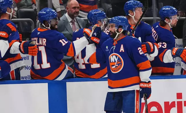 New York Islanders' Kyle Palmieri celebrates with teammates after scoring a goal during the first period of an NHL hockey game against the Vancouver Canucks Tuesday, Oct. 13, 2026, in Elmont, N.Y. (AP Photo/Frank Franklin II)