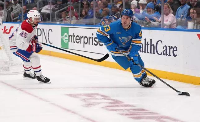 St. Louis Blues' Mason McTavish (83) looks to pass as Montreal Canadiens' Alexandre Carrier (45) defends during the second period of an NHL hockey game Tuesday, Oct. 27, 2026, in St. Louis. (AP Photo/Jeff Roberson)