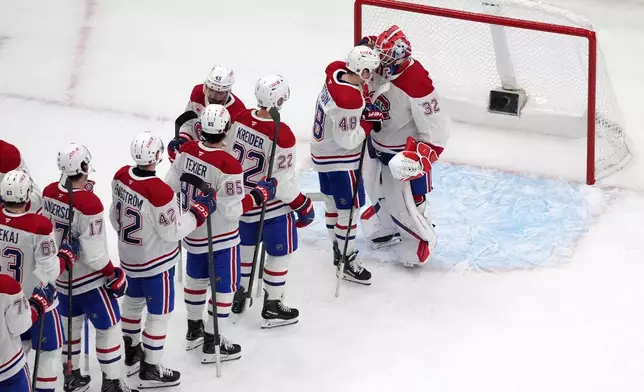 Montreal Canadiens goaltender Jacob Fowler (32) is congratulated by teammates after earning a shutout victory over the St. Louis Blues an NHL hockey game Tuesday, Oct. 27, 2026, in St. Louis. (AP Photo/Jeff Roberson)