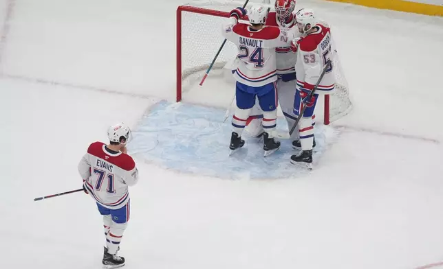 Montreal Canadiens goaltender Jacob Fowler (32) is congratulated by teammates Phillip Danault (24), Noah Dobson (53) and Jake Evans (71) after earning a shutout victory over the St. Louis Blues an NHL hockey game Tuesday, Oct. 27, 2026, in St. Louis. (AP Photo/Jeff Roberson)