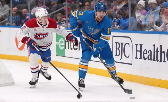 St. Louis Blues' Alexey Toropchenko (13) passes around Montreal Canadiens' Adam Engstrom (42) during the second period of an NHL hockey game Tuesday, Oct. 27, 2026, in St. Louis. (AP Photo/Jeff Roberson)