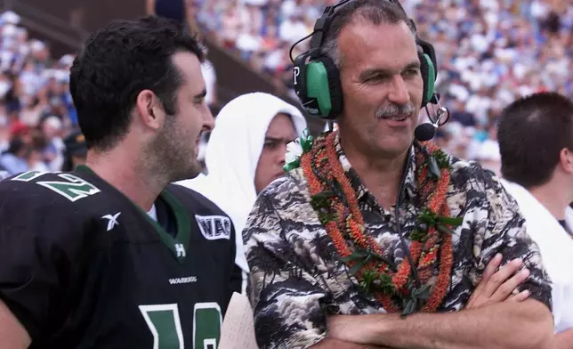 FILE - Hawaii coach June Jones and quarterback Nick Rolovich laugh during the fourth quarter action at Aloha Stadium in Honolulu on Dec. 8, 2001. (AP Photo/Ronen Zilberman, File)