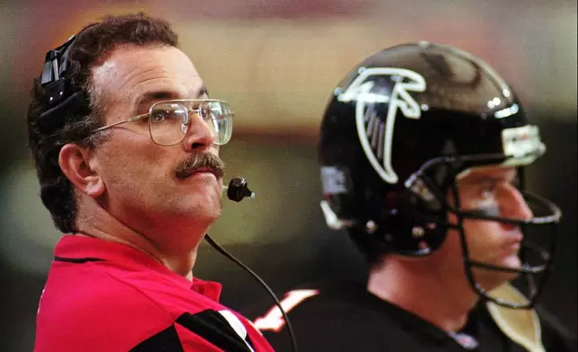 FILE - Atlanta Falcons head coach June Jones watches the clock while standing on the sidelines with quarterback Jeff George (1) during the game against the St. Louis Rams on Nov. 19, 1995. (AP Photo/John Bazemore, File)
