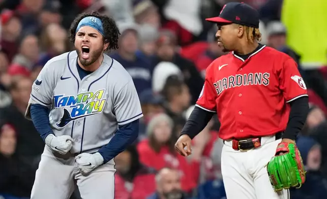 Tampa Bay Rays' Jonathan Aranda celebrates after RBI-single as Cleveland Guardians third baseman José Ramírez looks on during the seventh inning in Game 4 of an American League Championship Series baseball game in Cleveland, Saturday, Oct. 17, 2026. (AP Photo/David J. Phillip)