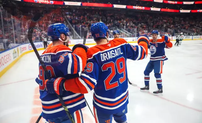 Edmonton Oilers' Vasily Podkolzin (92) and Leon Draisaitl (29) celebrate Draisaitl's goal against the Minnesota Wild during the second period of an NHL hockey game in Edmonton, Tuesday, Oct. 20, 2026. (Codie McLachlan/The Canadian Press via AP)
