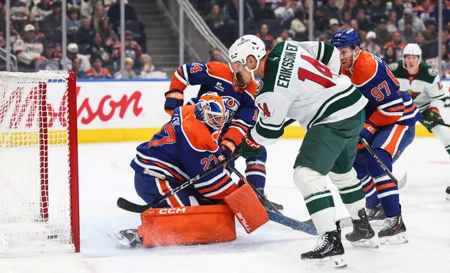 Minnesota Wild's Joel Eriksson Ek, second from right, scores on Edmonton Oilers goaltender Devon Levi (27) during the first period of an NHL hockey game in Edmonton, Alberta, Tuesday, Oct. 20, 2026. (Codie McLachlan/The Canadian Press via AP)