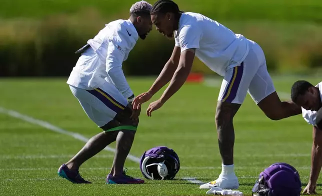 Minnesota Vikings wide receivers Odell Beckham Jr., left, and Justin Jefferson, middle, stretch during an NFL football practice Wednesday, Oct. 7, 2026, in Eagan, Minn. (AP Photo/Abbie Parr)