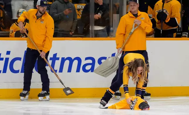 A catfish is removed from the ice before the start of an NHL hockey game between the Nashville Predators and the Minnesota Wild, Thursday, Oct. 1, 2026, in Nashville, Tenn. (AP Photo/George Walker IV)