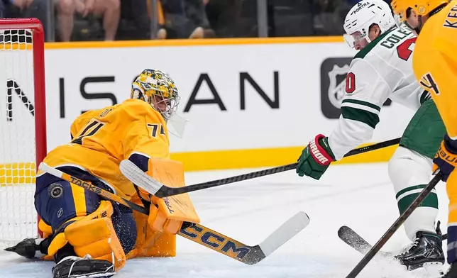 Minnesota Wild left wing Blake Coleman, second from right, scores a goal past Nashville Predators goaltender Juuse Saros, left, during the first period of an NHL hockey game Thursday, Oct. 1, 2026, in Nashville, Tenn. (AP Photo/George Walker IV)
