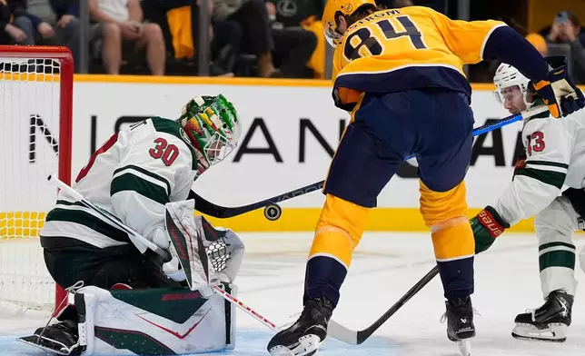 Minnesota Wild goaltender Jesper Wallstedt (30) blocks a shot on goal by Nashville Predators center Adam Edstrom (84) during the second period of an NHL hockey game Thursday, Oct. 1, 2026, in Nashville, Tenn. (AP Photo/George Walker IV)