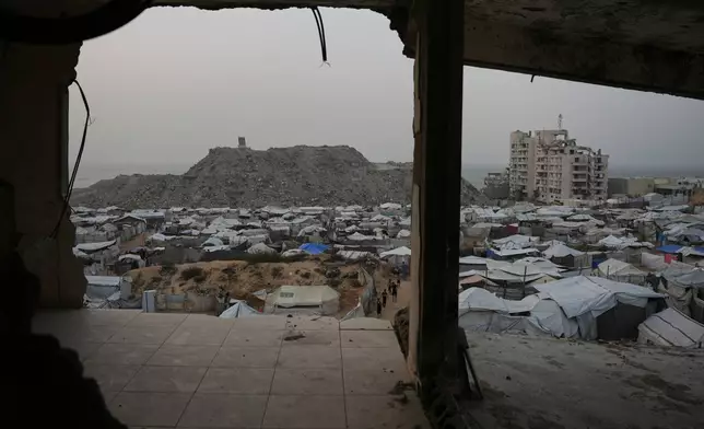Palestinians walk among tents at a tent camp for displaced people in Gaza City, Friday, Oct. 16, 2026. (AP Photo/Abdel Kareem Hana)