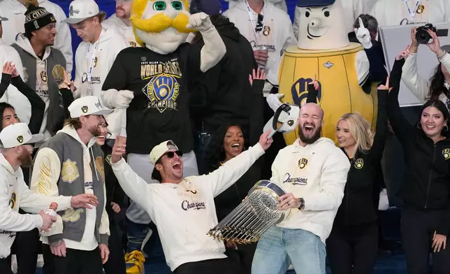Milwaukee Brewers Aaron Ashby, right, holds up the Commissioner's Trophy as he celebrates with teammates during a rally at the baseball team's World Series Parade, Friday, Oct. 30, 2026, in Milwaukee. (AP Photo/Nam Huh)