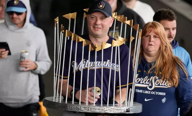 A Milwaukee Brewers fan dressed as the Commissioner's Trophy arrives for a rally during the baseball team's World Series parade, Friday, Oct. 30, 2026, in Milwaukee. (AP Photo/Nam Huh)