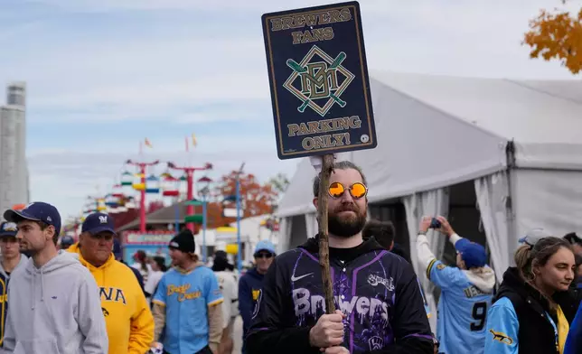A Milwaukee Brewers' fan holds up a sign as he waits for the baseball team to arrive for a rally during their World Series parade, Friday, Oct. 30, 2026, in Milwaukee. (AP Photo/Nam Huh)