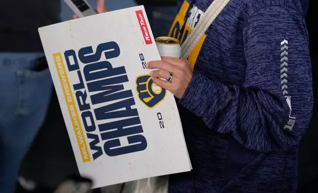 A fan holds a sign as they arrive for a rally during the baseball team's World Series parade, Friday, Oct. 30, 2026, in Milwaukee. (AP Photo/Nam Huh)