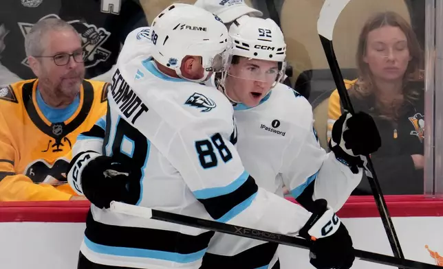 Utah Mammoth's Logan Cooley (92) celebrates after his first of two goals with Nate Schmidt (88) in the first period of an NHL hockey game against the Pittsburgh Penguins in Pittsburgh, Thursday, Oct. 29, 2026. (AP Photo/Gene J. Puskar)