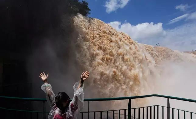 A tourist stands on a walkway overlooking Iguazu Falls in Foz do Iguacu, Brazil, Friday, Oct. 16, 2026. (AP Photo/Jorge Saenz)