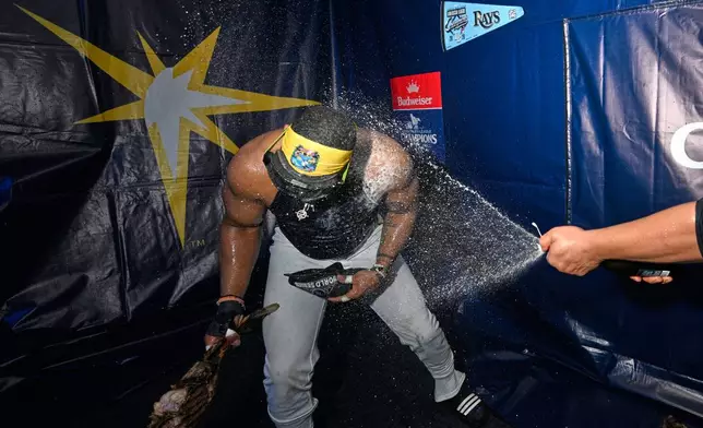 Tampa Bay Rays designated hitter Yandy Díaz celebrates their win in the locker room against the Cleveland Guardians in Game 6 of an American League Championship Series baseball game in St. Petersburg, Fla. Monday, Oct. 19, 2026.(AP Photo/Phelan M. Ebenhack)