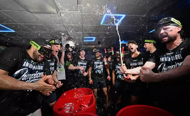 The Tampa Bay Rays celebrate their win in the locker room against the Cleveland Guardians in Game 6 of an American League Championship Series baseball game in St. Petersburg, Fla. Monday, Oct. 19, 2026.(AP Photo/Phelan M. Ebenhack)