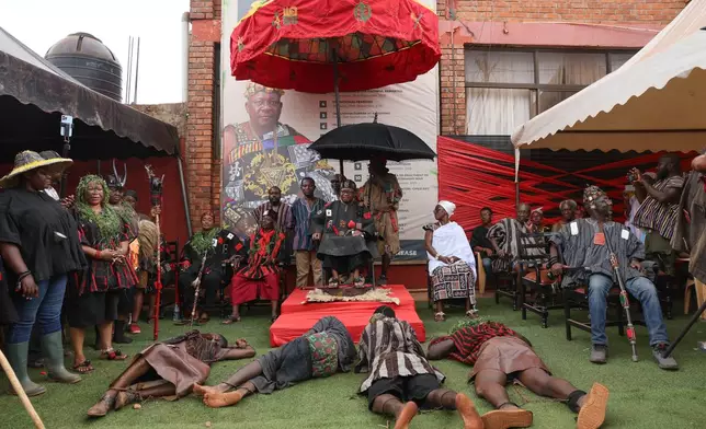 Young men play the role of prisoners brought before Osabarima Asiedu Okoo Ababio III, Benkumhene of the Akuapem Traditional Area, during the re-enactment of the Akatamanso War as part of the Odwira Festival celebrations in Larteh, Ghana, Wednesday, Sept. 30, 2026. (AP Photo)