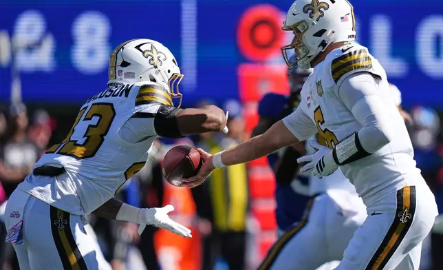 New Orleans Saints quarterback Tyler Shough (6) hands the ball off to Saints running back CJ Donaldson (43) during the first half of an NFL football game against the New York Giants in East Rutherford, N.J., Sunday, Oct. 18, 2026. (AP Photo/Frank Franklin II)