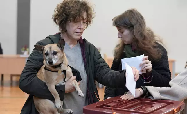 Voters cast their ballots at the parliamentary election at a polling station in Riga, Latvia, Saturday, Oct. 3, 2026. (AP Photo/Roman Koksarov)