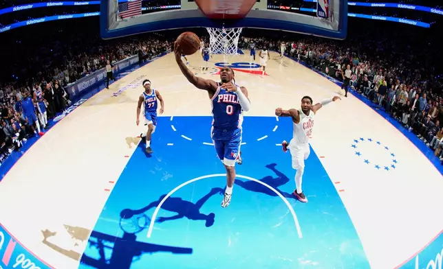 Philadelphia 76ers' Tyrese Maxey (0) goes up for a shot past Cleveland Cavaliers' Donovan Mitchell (45) during the second half of an NBA basketball game Thursday, Oct. 22, 2026, in Philadelphia. (AP Photo/Matt Slocum)