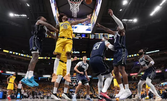 Indiana Pacers forward-guard Kelly Oubre Jr. (10) shoots against a group of Dallas Maverick defenders in the first half of an NBA basketball game in Indianapolis, Friday, Oct. 23, 2026. (AP Photo/AJ Mast)