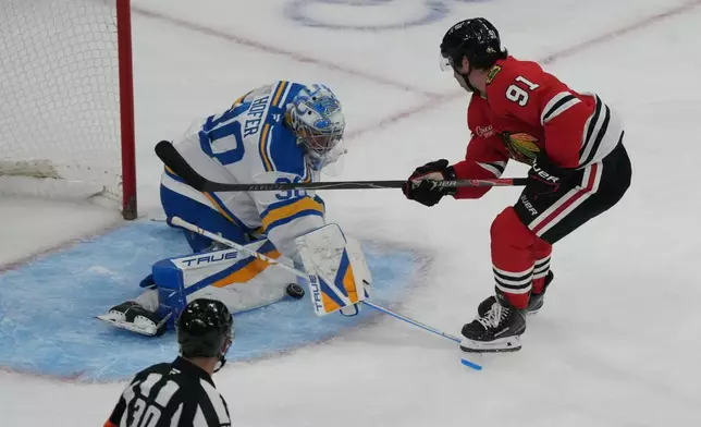St. Louis Blues goaltender Joel Hofer, left, makes a save on Chicago Blackhawks center Frank Nazar, right, during the first period of an NHL hockey game, Tuesday, Oct. 6, 2026, in Chicago. (AP Photo/David Banks)