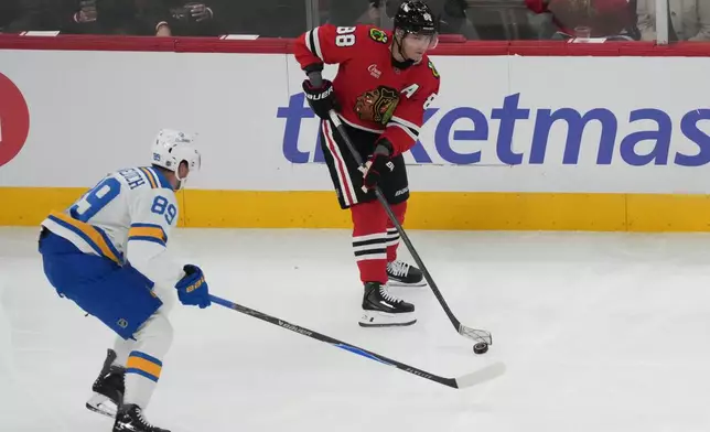 St. Louis Blues left wing Pavel Buchnevich, left, defends Chicago Blackhawks right wing Patrick Kane, right, during the first period of an NHL hockey game, Tuesday, Oct. 6, 2026, in Chicago. (AP Photo/David Banks)