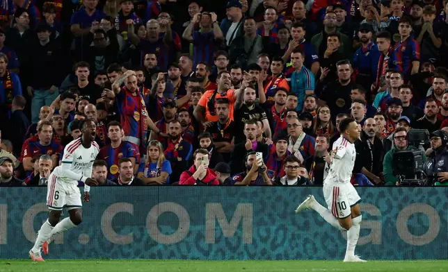 Real Madrid's Kylian Mbappe, right, celebrates after scoring his side's second goal during a Spanish La Liga soccer match between FC Barcelona and Real Madrid in Barcelona, Spain, Sunday, Oct. 25, 2026. (AP Photo/Joan Monfort)