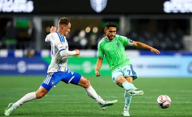 Seattle Sounders midfielder Cristian Roldan, right, passes away from CF Montréal midfielder Fabian Herbers, left, during the first half of an MLS soccer match, Saturday, Oct. 17, 2026, in Seattle. (AP Photo/Rio Giancarlo)