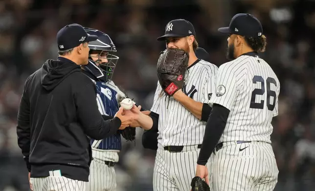 New York Yankees manager Aaron Boone, left, takes the ball from pitcher Paul Blackburn, right rear, as Luis García Jr. (26) and Austin Wells, left, rear, stand by during the eighth inning in Game 3 of baseball's American League Division Series against the Tampa Bay Rays, Wednesday, Oct. 7, 2026, in New York. (AP Photo/Yuki Iwamura)