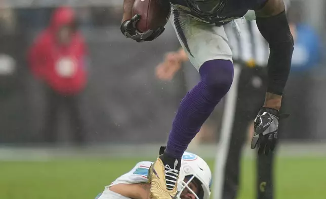 Baltimore Ravens running back Derrick Henry (22) runs the ball over Tennessee Titans safety Amani Hooker (37) during the second half of an NFL football game in Baltimore, Sunday, Oct. 4, 2026. (AP Photo/Stephanie Scarbrough)